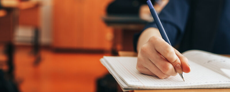 The student writes in a notebook