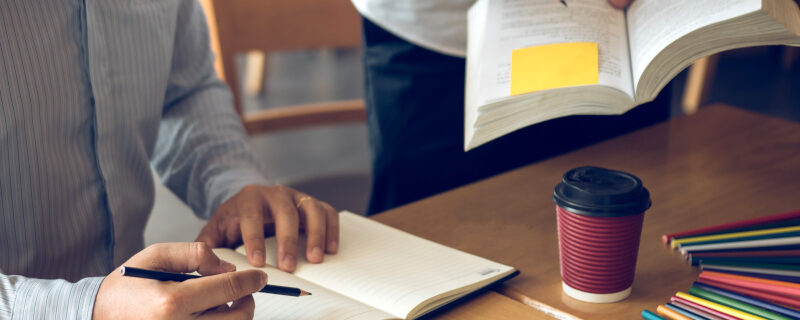 Teenage student works on homework in his room and writing in not